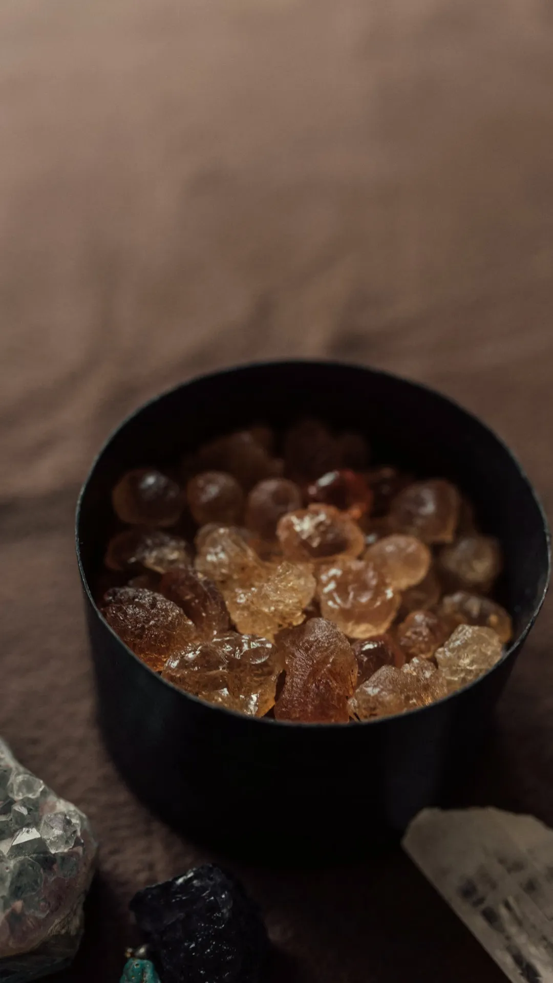 Bowl of amber resin tears on dark linen