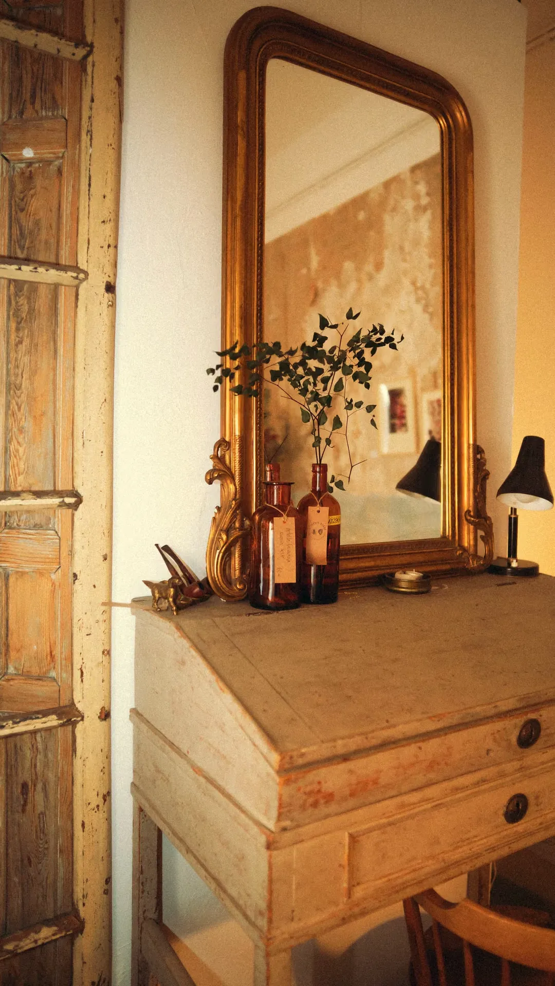 Antique desk with a gilt mirror and perfume bottles